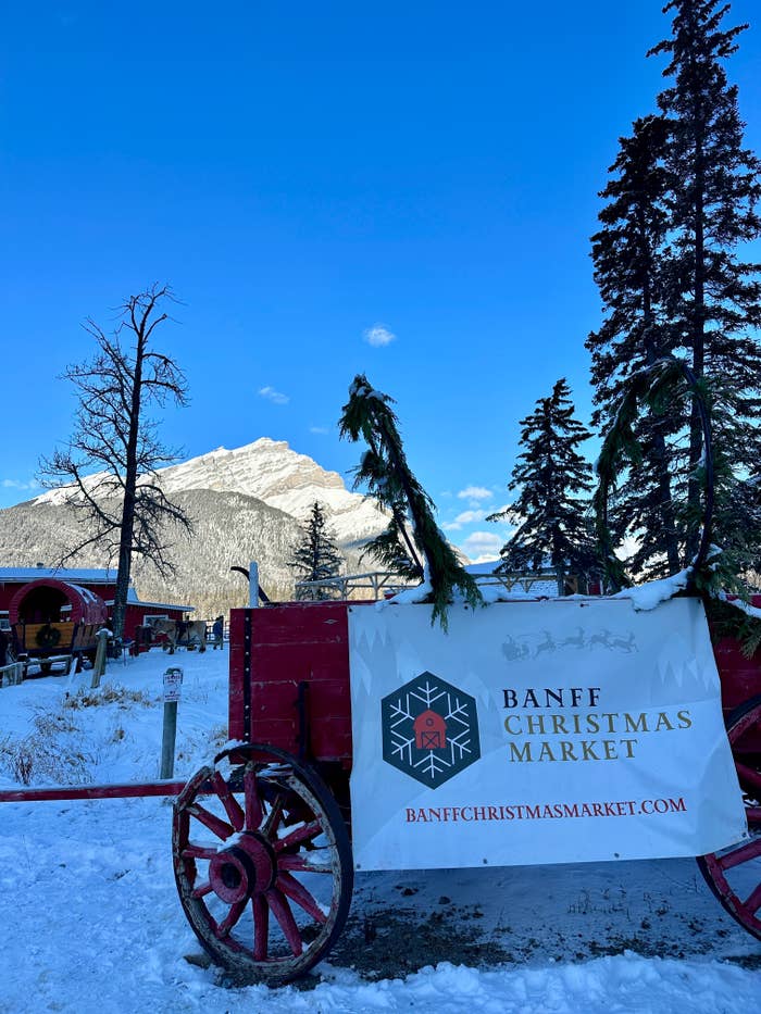 A sign of the Banff Christmas Market with the Rocky Mountains in the background