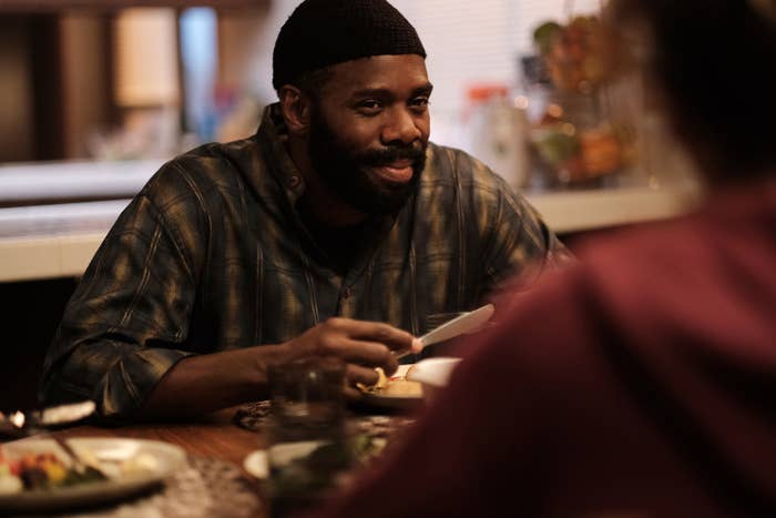 Colman sitting at a dinner table in a scene from "Euphoria"