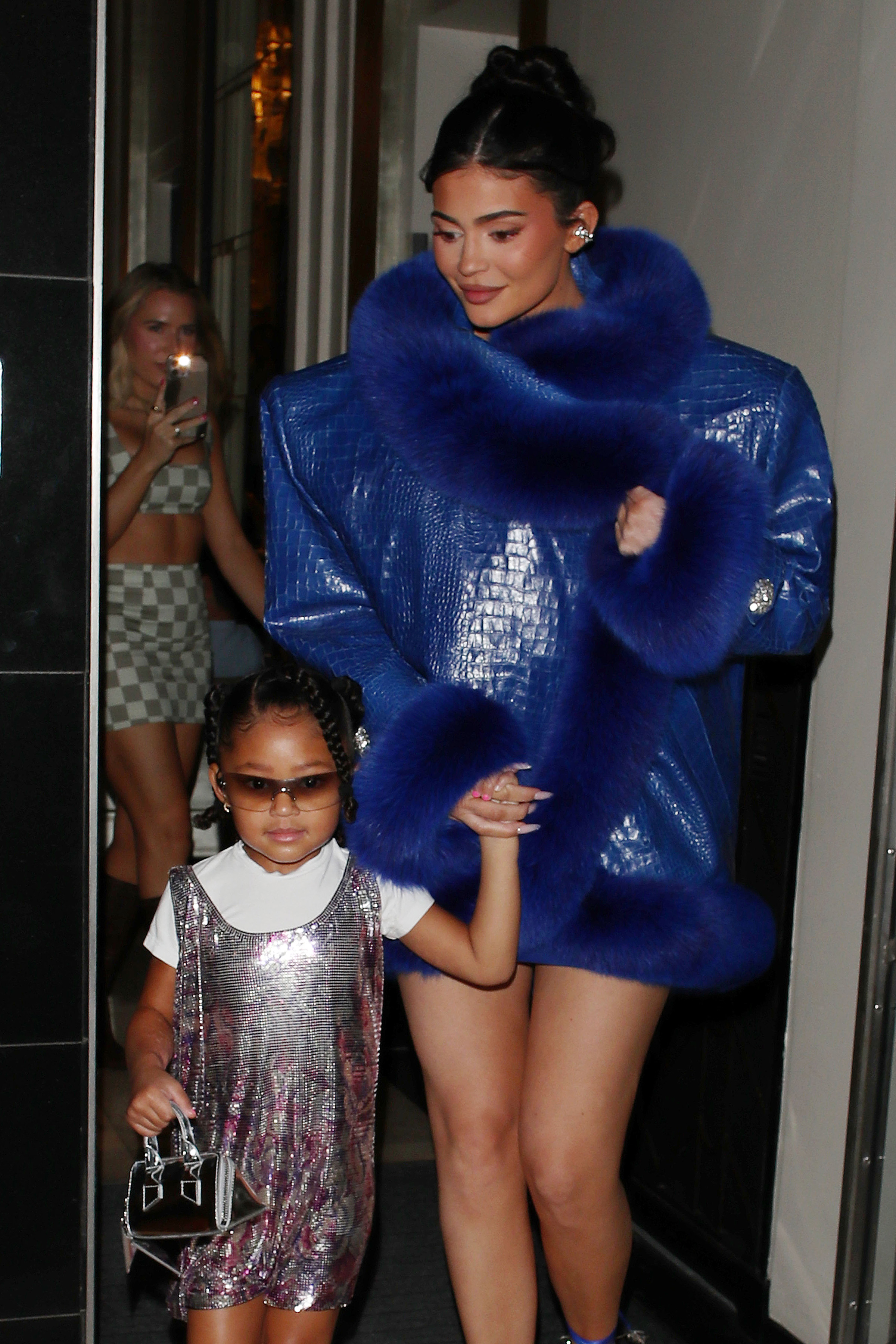 Closeup of Kylie and Stormi walking out of a building hand in hand