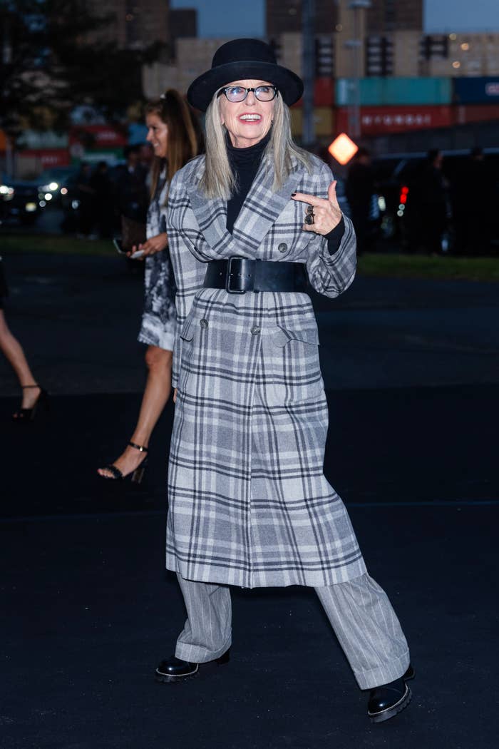 Closeup of Diane Keaton in a long plaid coat and a hat