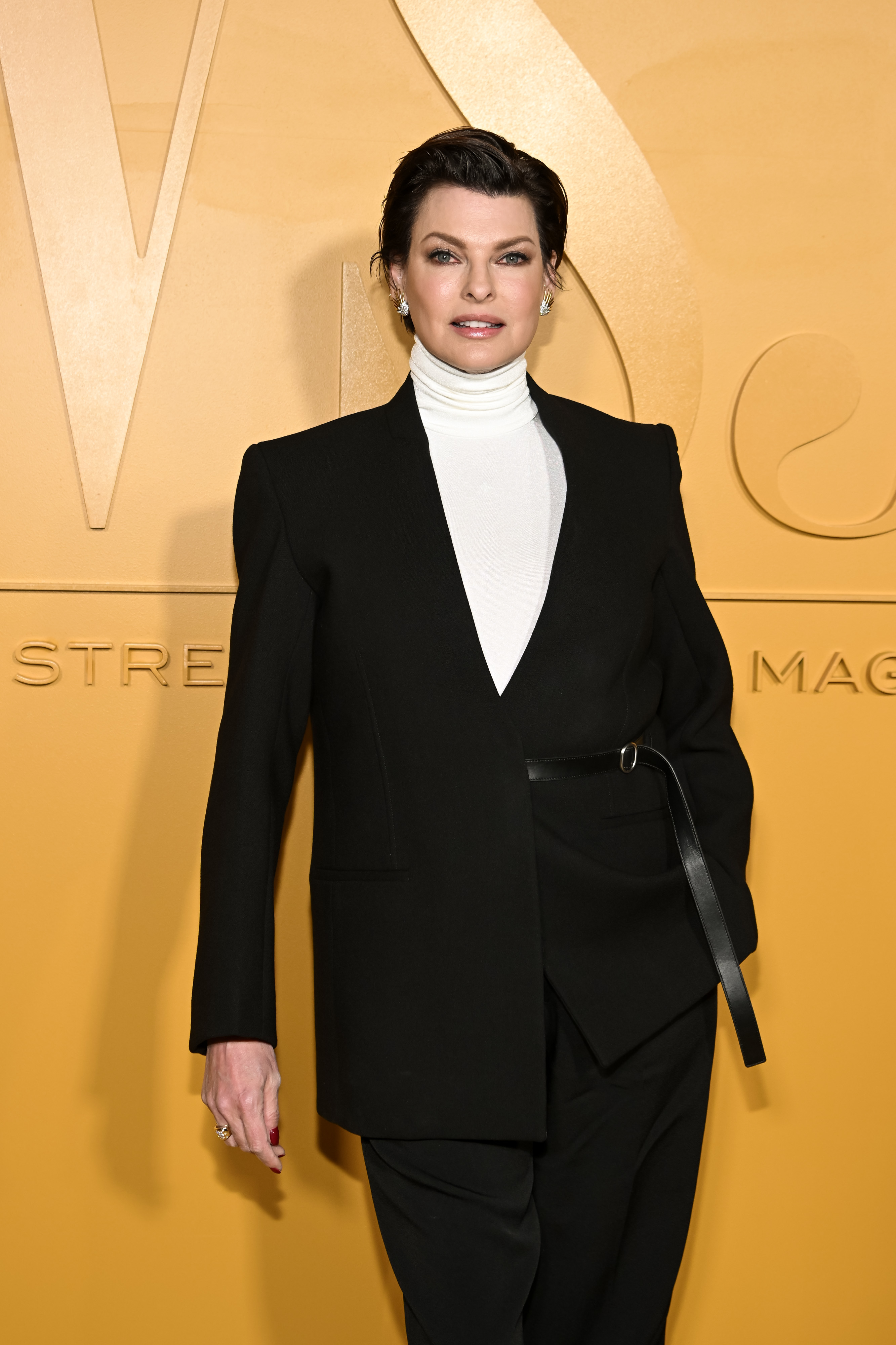 Closeup of Linda Evangelista on the red carpet wearing a turtleneck and blazer