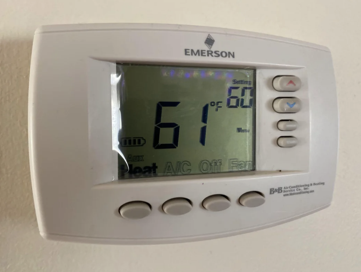 A thermostat set to 61 degrees