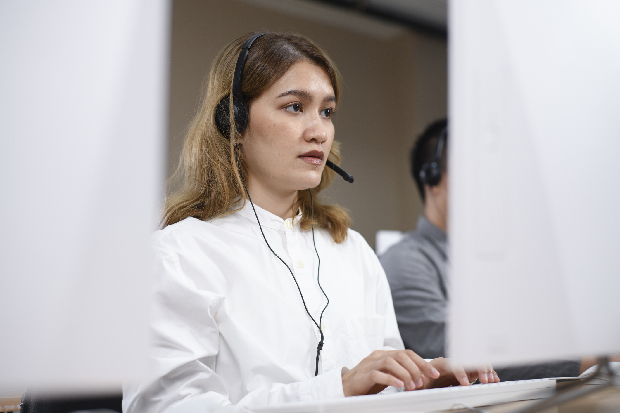 person typing while wearing a headset