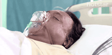 A person on a hospital bed with an oxygen mask