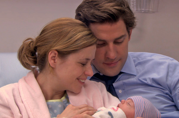 Jim and Pam from The Office smiling as they look down at their baby