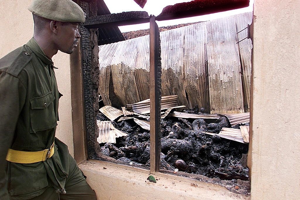 A soldier views the burned remains of up to 250 Ugandans of Movement for the Restoration of the Ten Commandments of God
