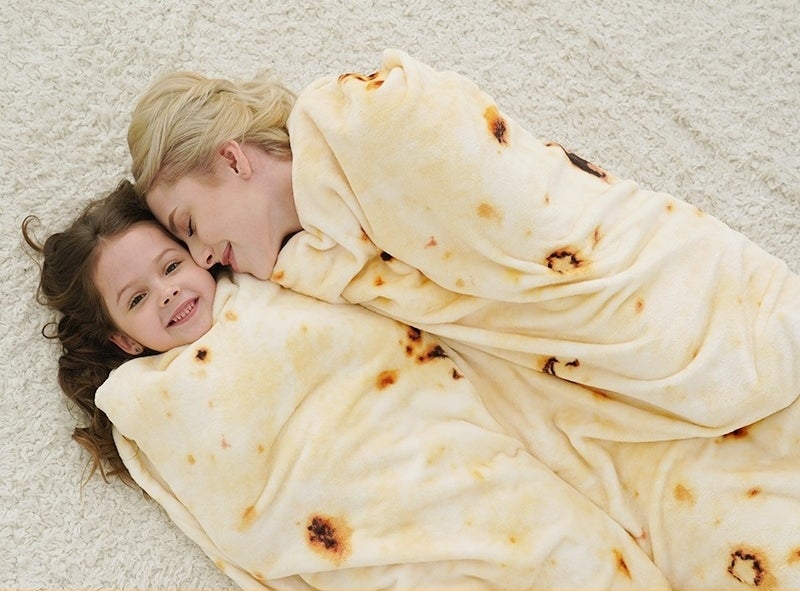 adult and child model curled up in blanket