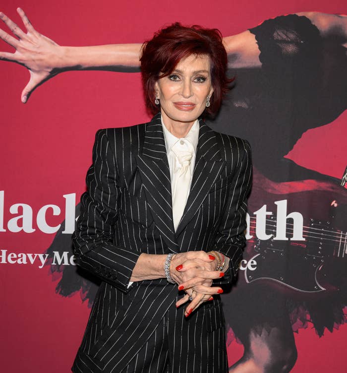 Closeup of Sharon Osbourne on the red carpet in a pinstriped pantsuit