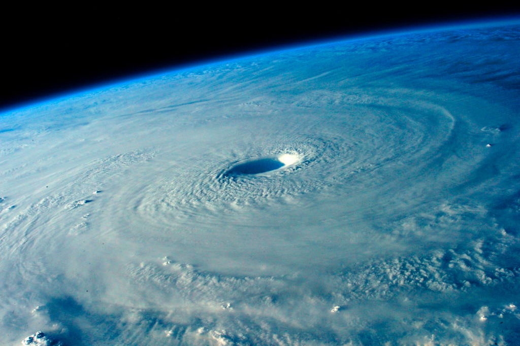 A swirling, spherical mass with a hole in the center as seen from space