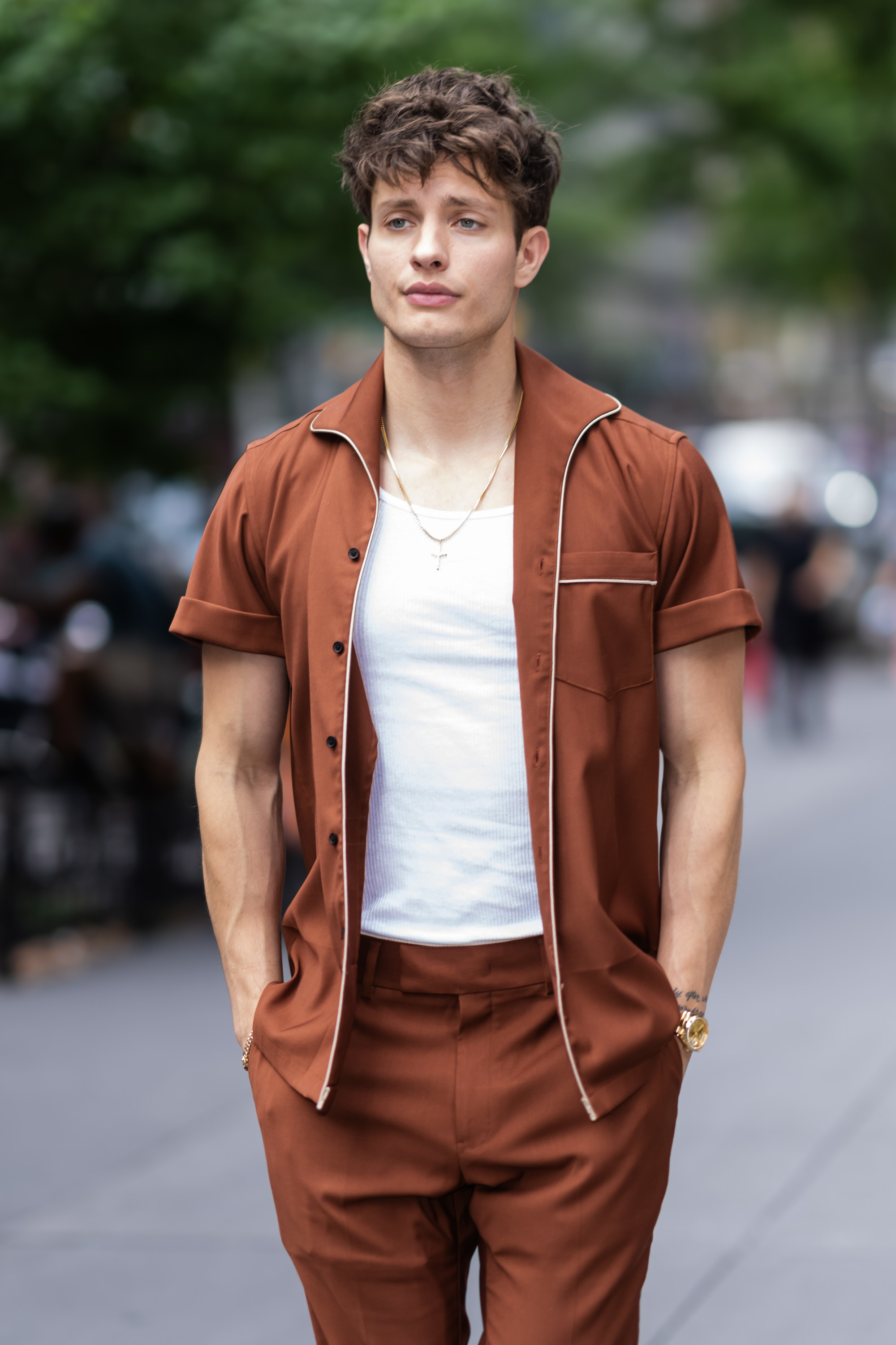 Closeup of Matt Rife outside in an open shirt and a tank top underneath