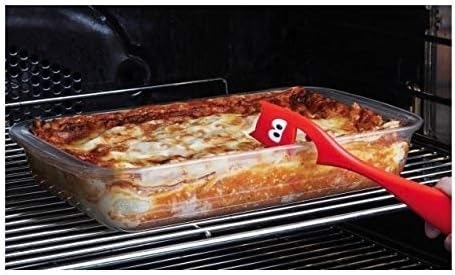 devil-shaped oven pull on top of lasagna pan in oven