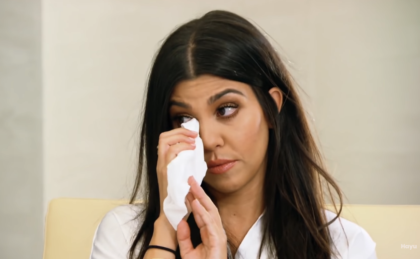 Close-up of Kourtney wiping her eye with tissues