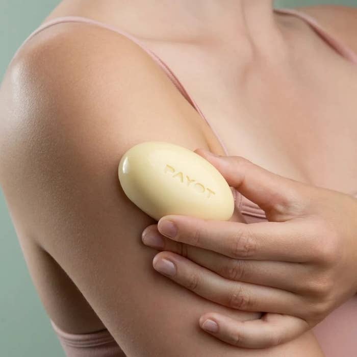 model holding small solid body massage bar