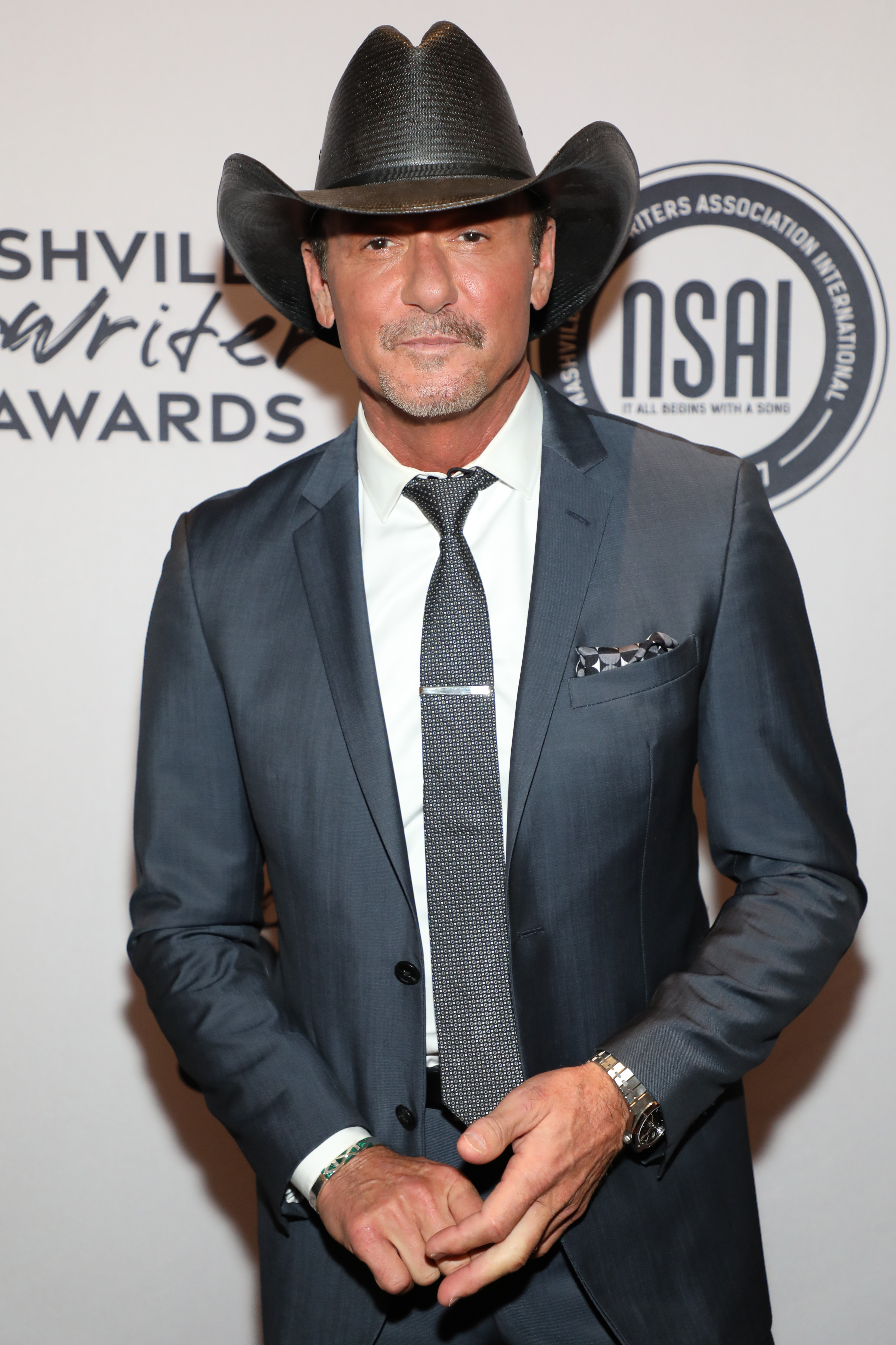 Tim in a Western-style hat and suit and tie at a media event