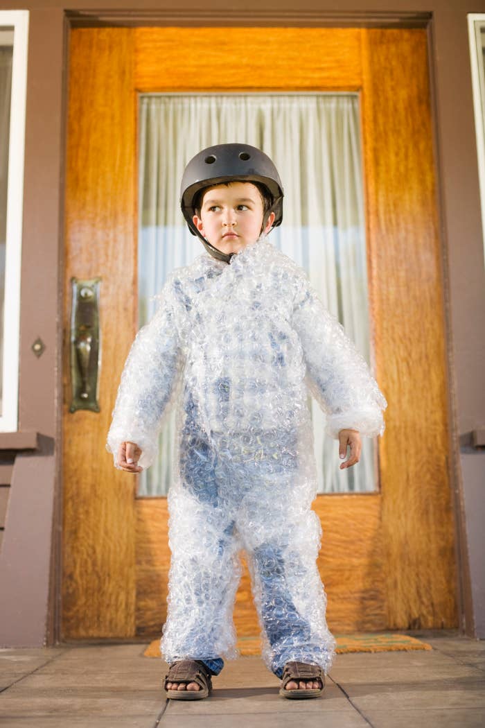 kid covered in bubble wrap and wearing a helmet