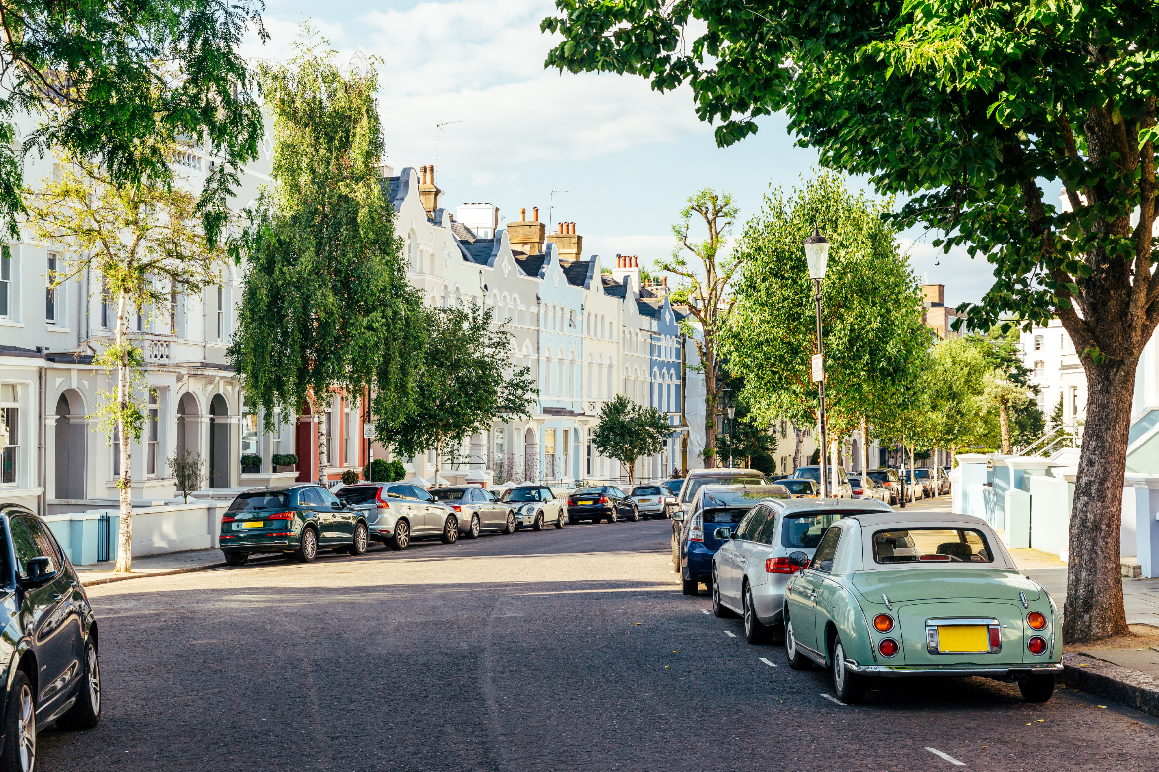 Residential London street, with charming townhouses and cars parked on the road
