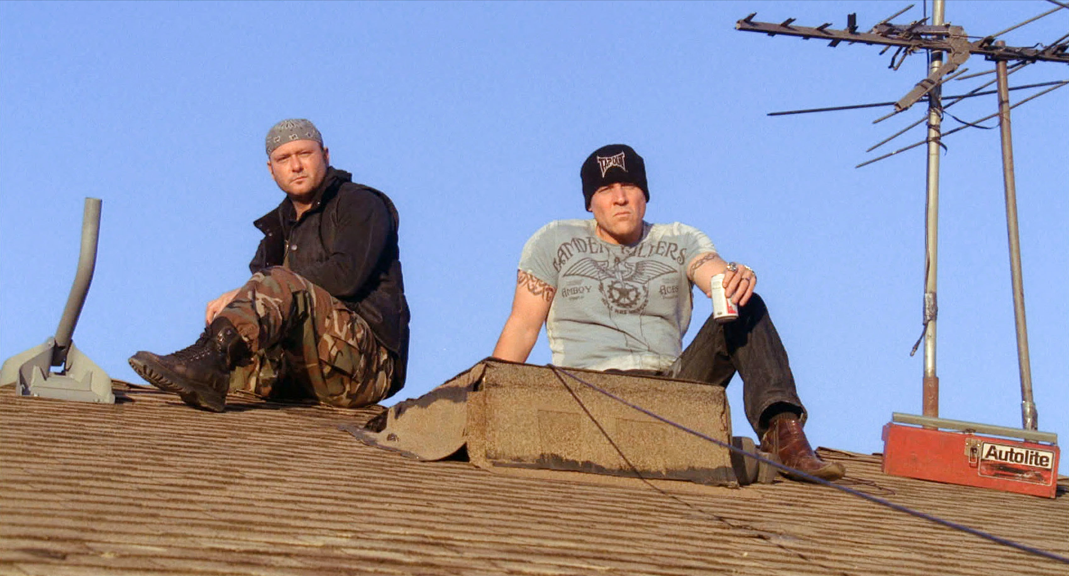 Tim McGraw and Jon Favreau and sitting on a roof