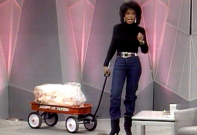 Oprah pulling a wagon loaded with animal fat
