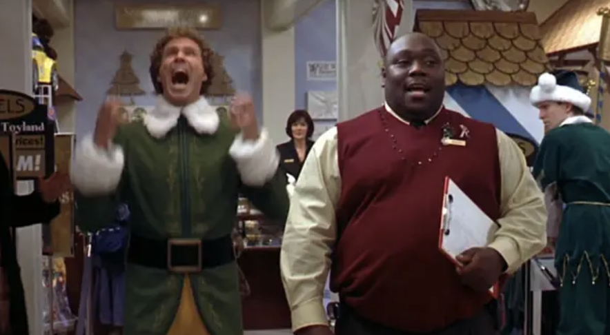 A scene from &quot;Elf&quot; where Buddy is jumping for joy in the Christmas-decorated department store