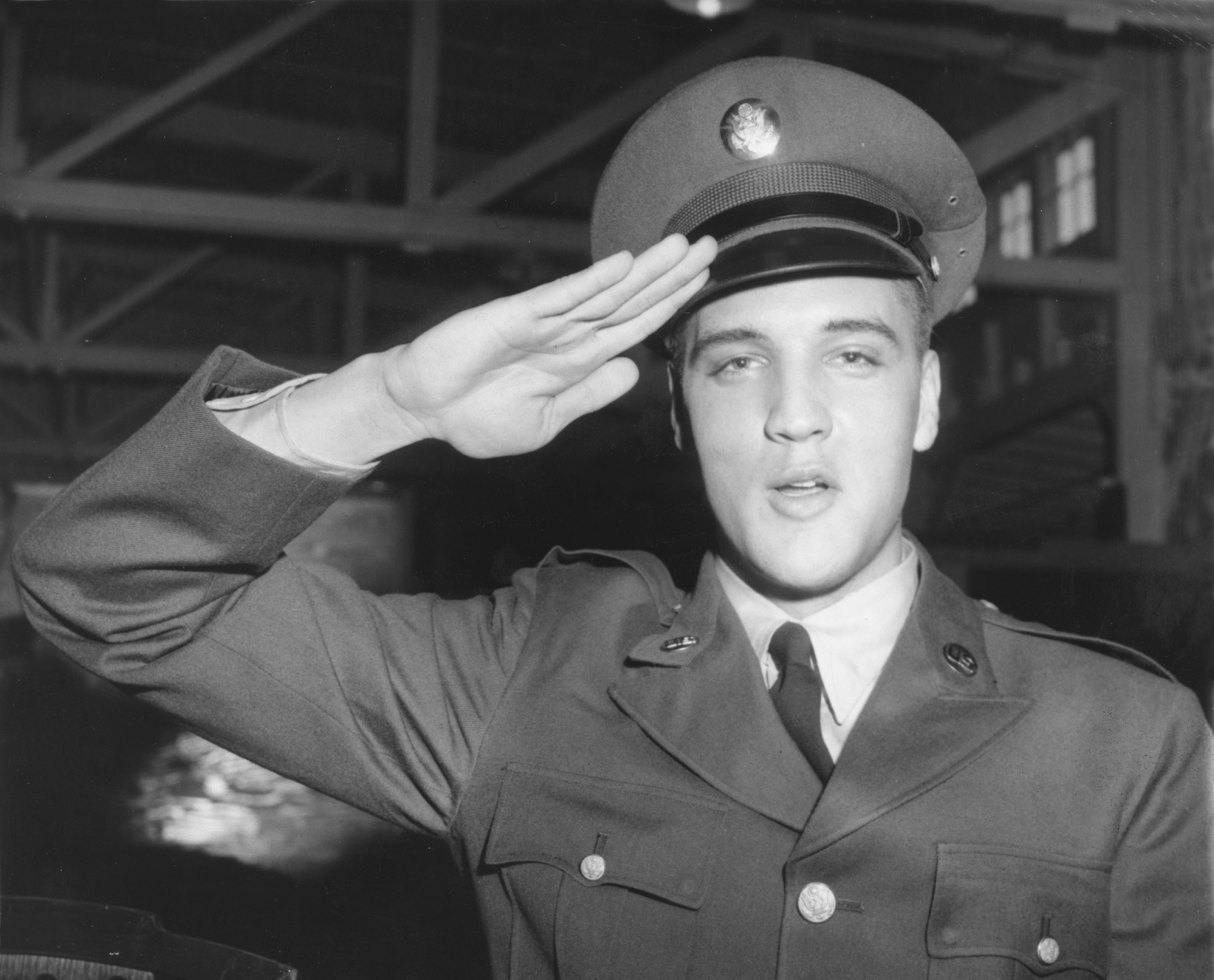 Close-up of the real Elvis in a military uniform giving a salute