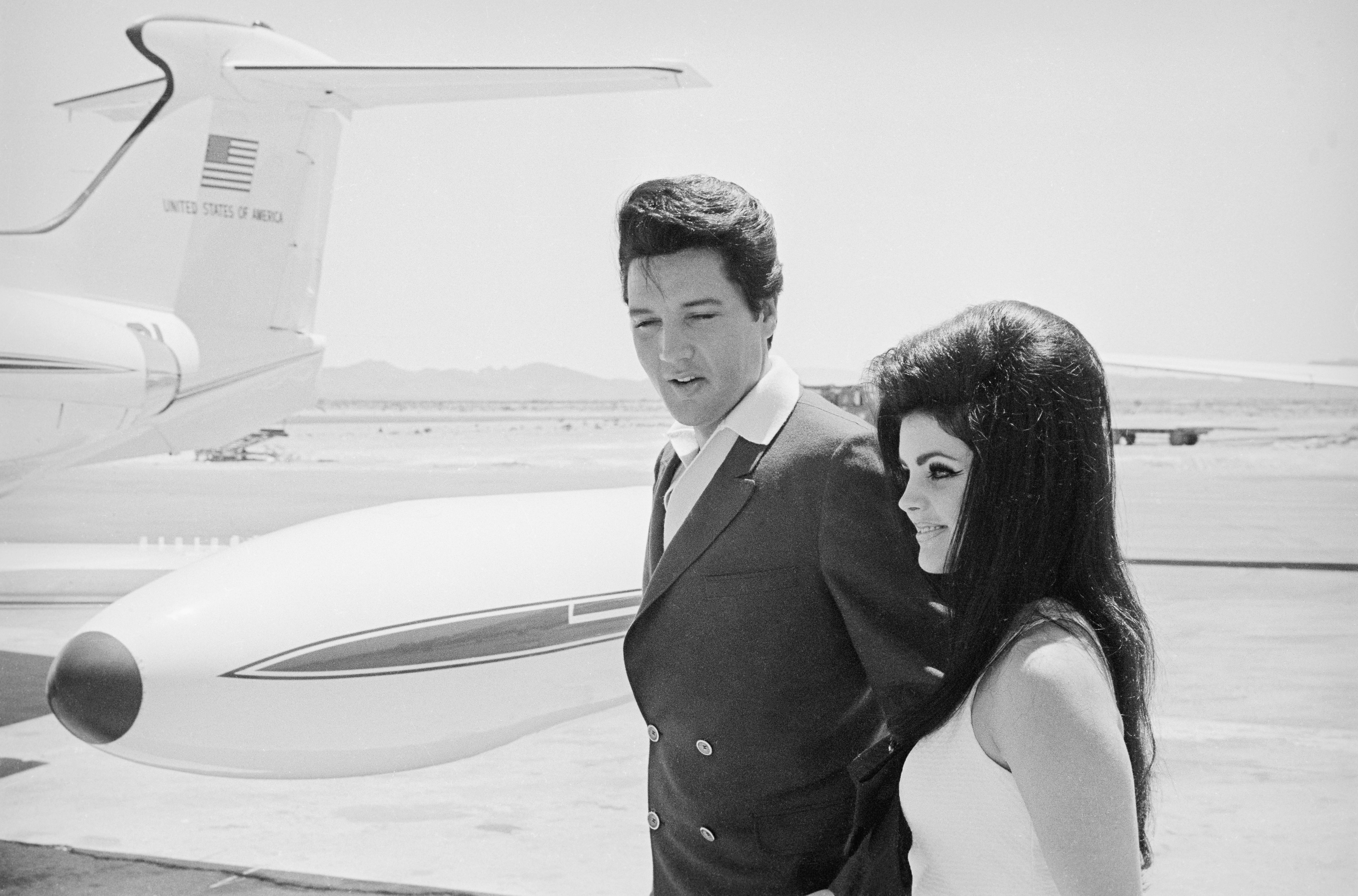 Close-up of the real Elvis and Priscilla in front of a plane