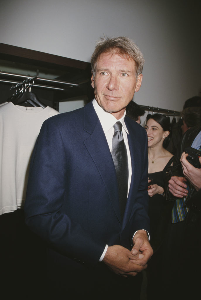 Close-up of Harrison smiling in a suit and tie