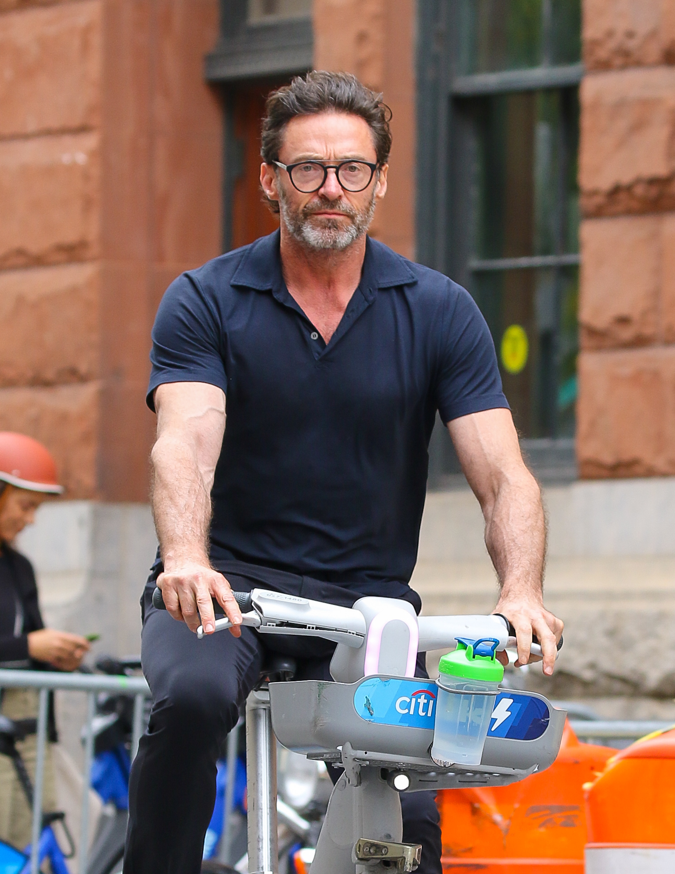 Close-up of Hugh on a scooter and wearing a T-shirt and pants