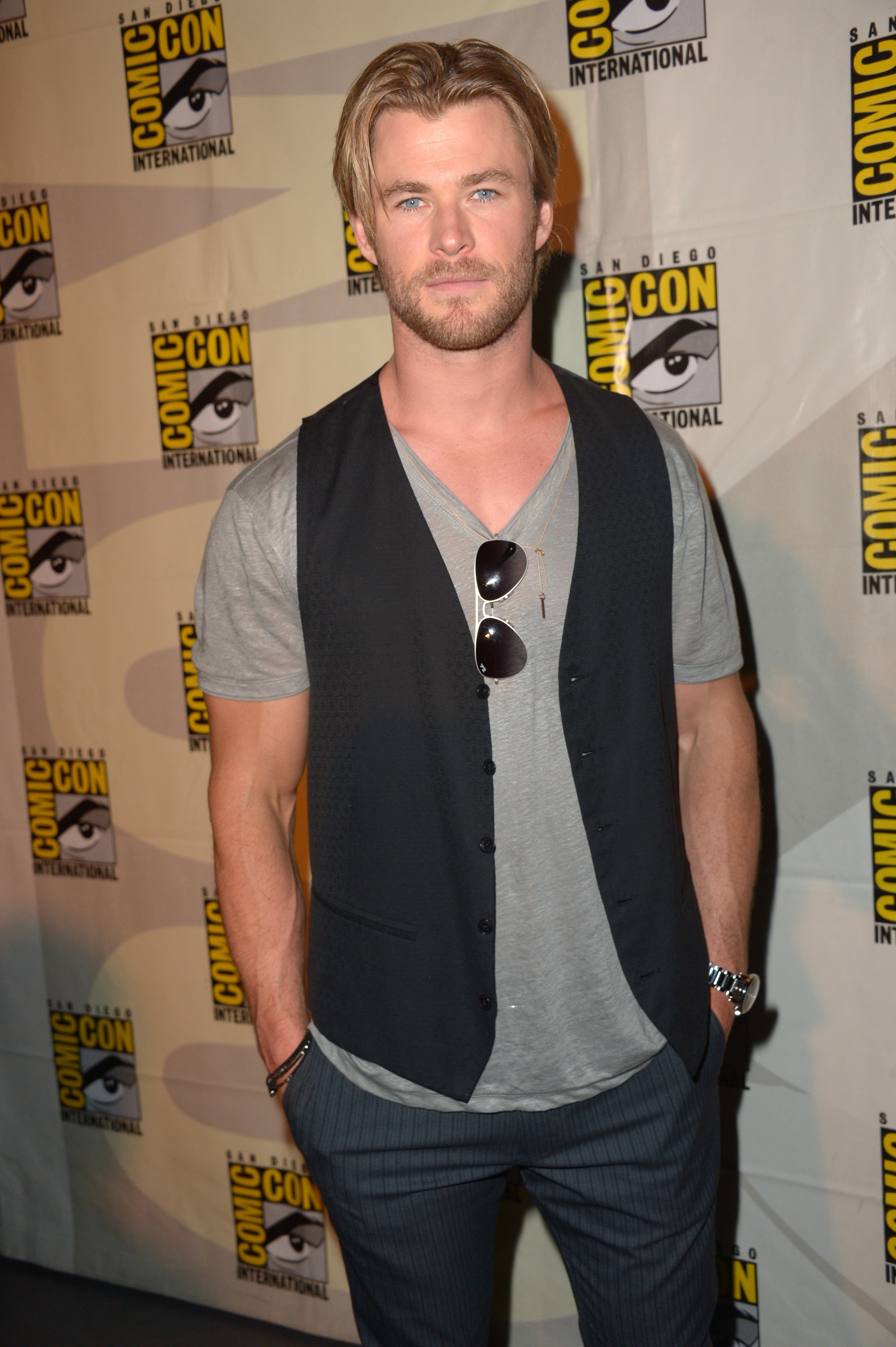 Close-up of Chris in a T-shirt, vest, and pants at a media event