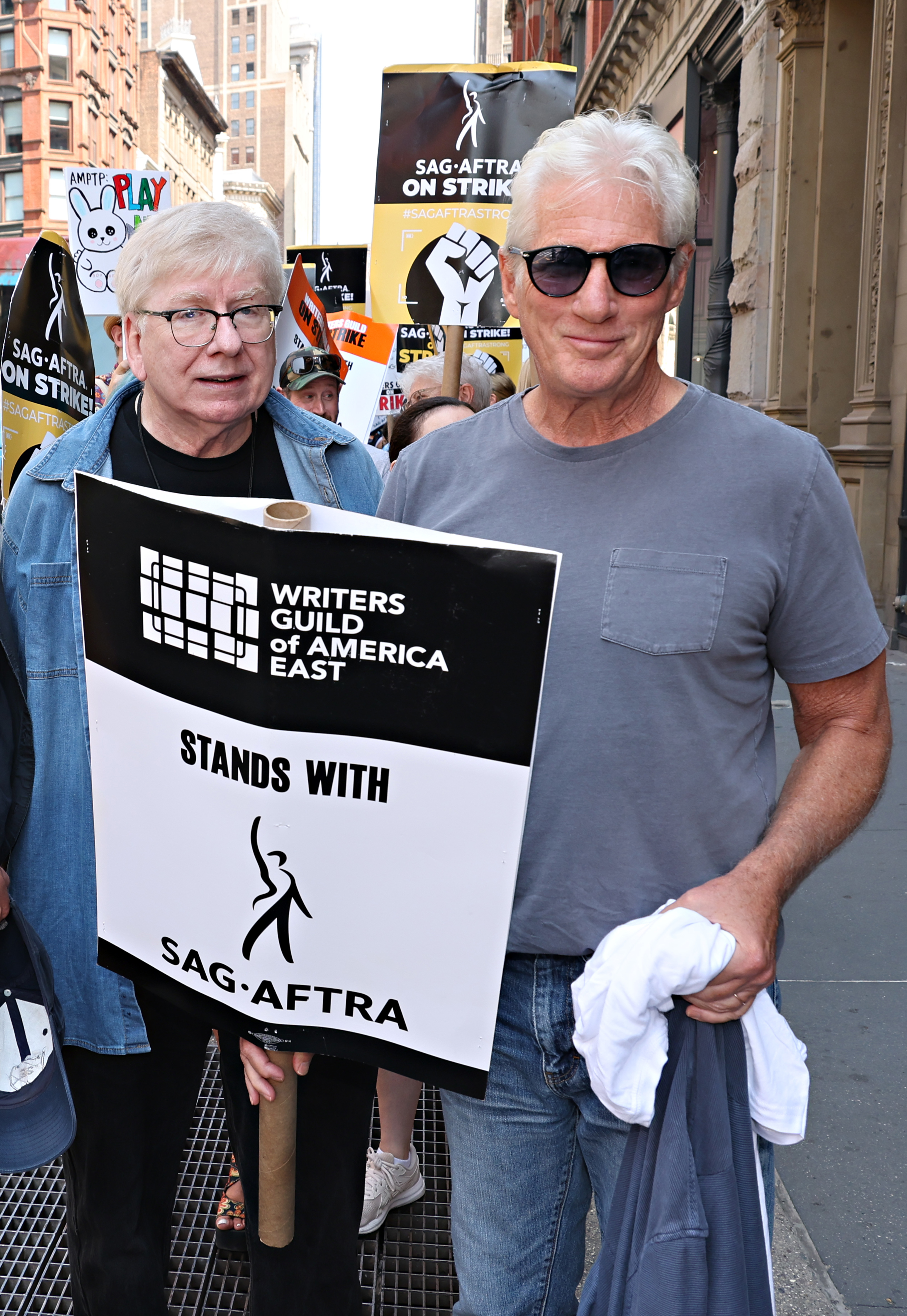 Close-up of Richard smiling and wearing a T-shirt and jeans on the SAG-AFTRA picket line