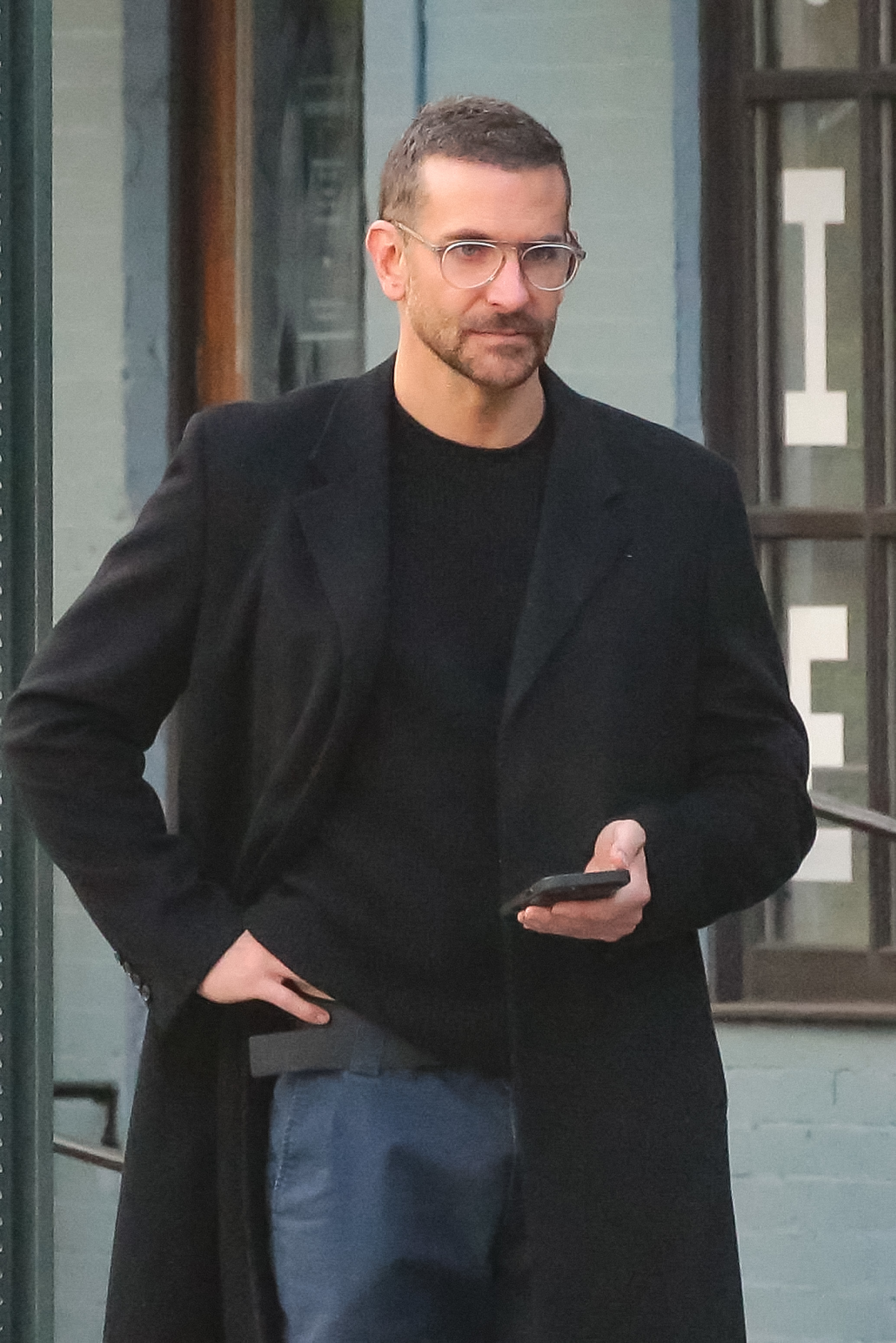 Close-up of Bradley wearing glasses and a coat