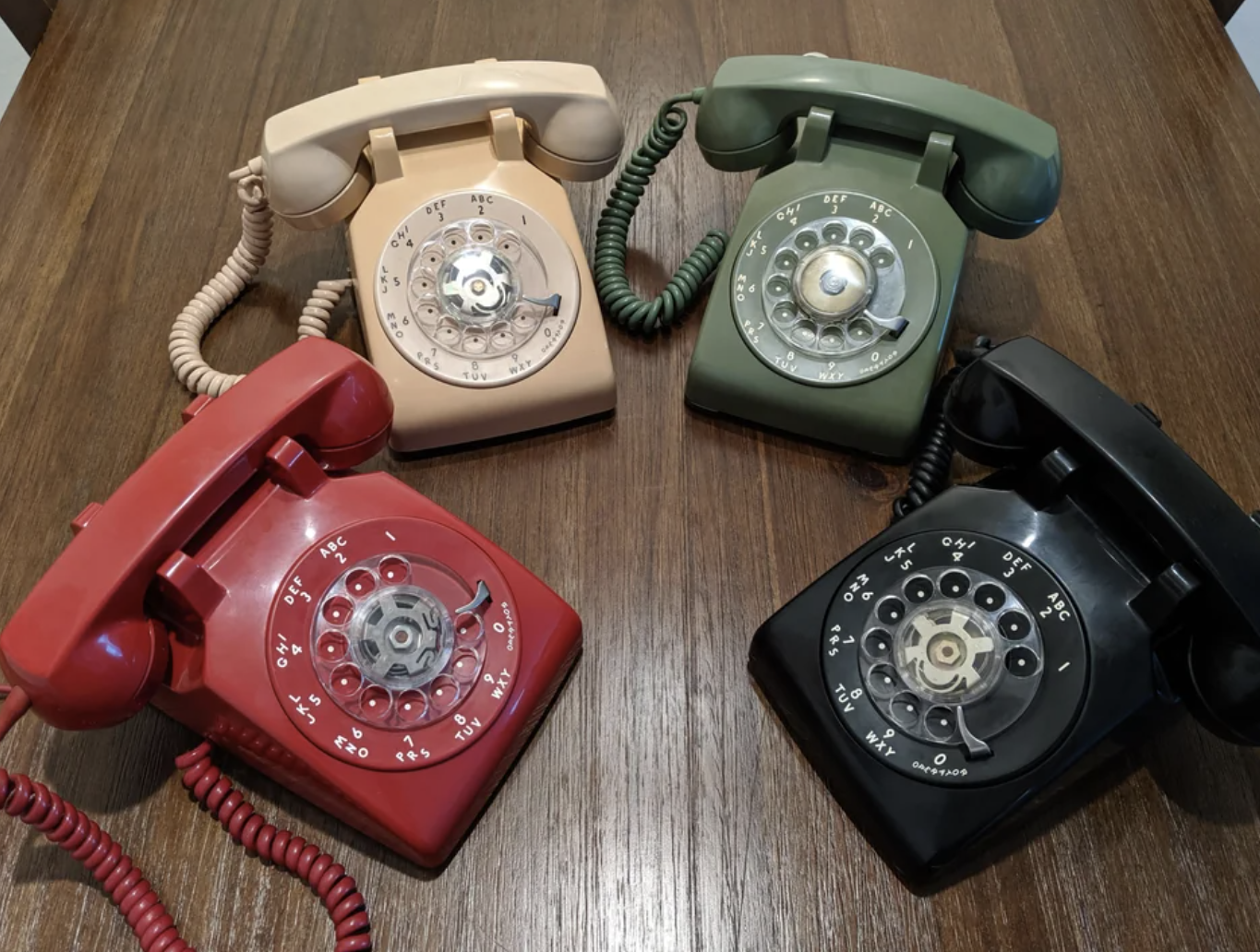 Four old-fashioned phones are sitting on a table
