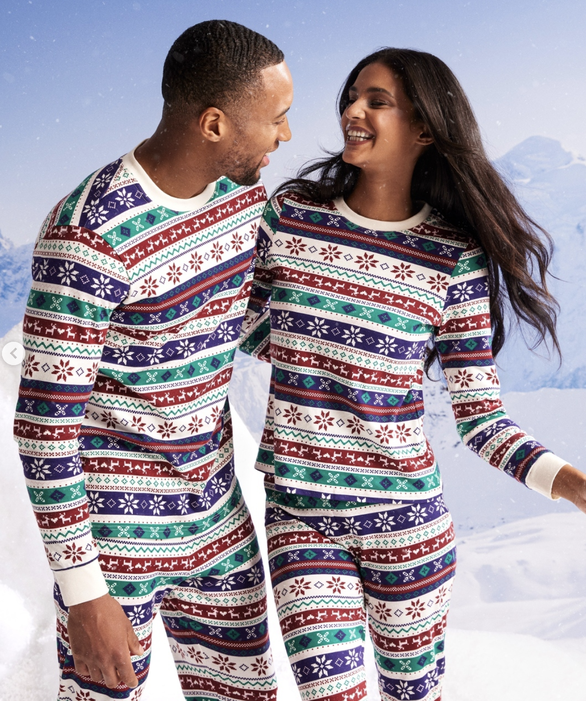 Two adults wear matching holiday-themed striped pyjamas.
