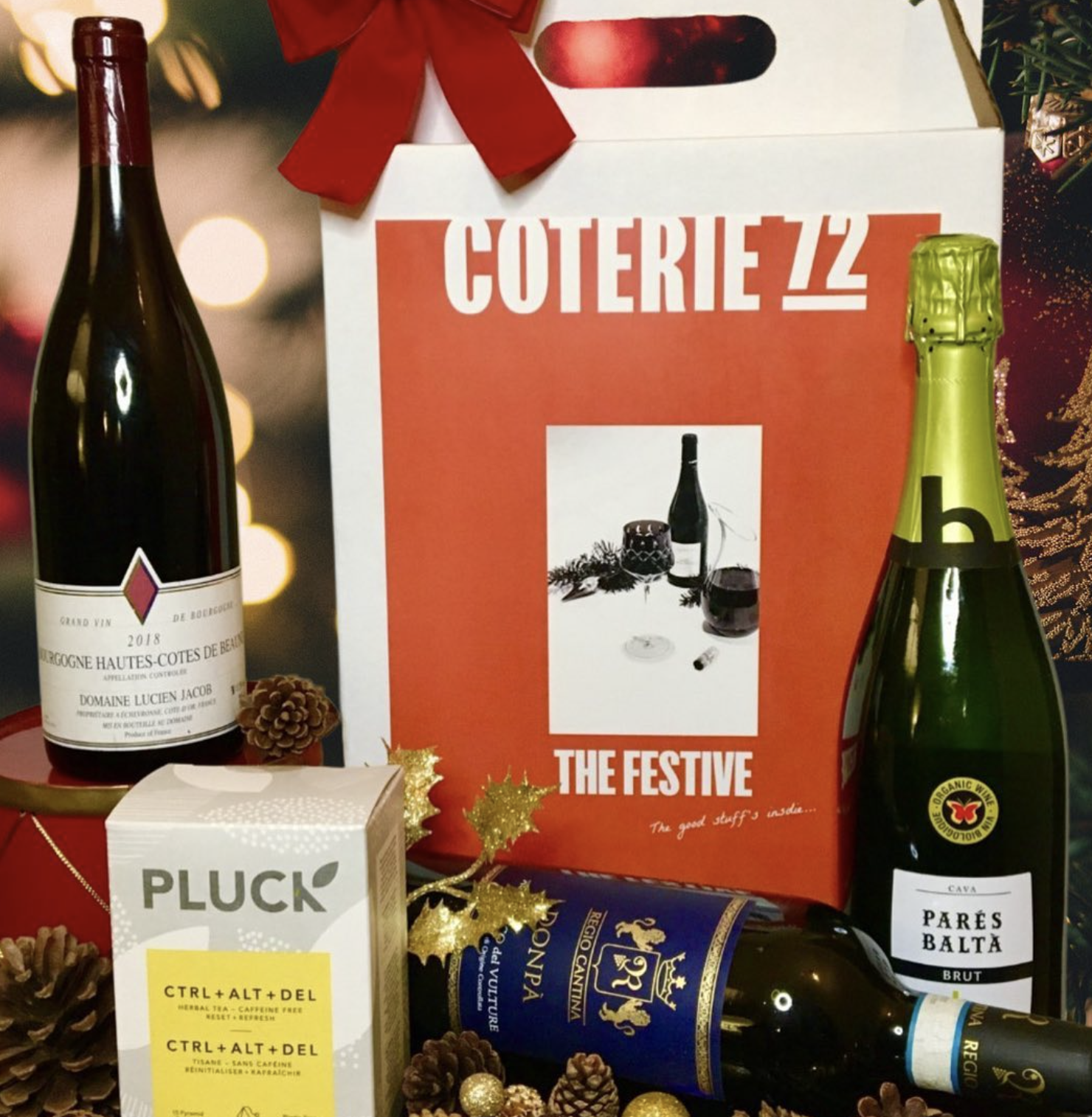 3 wine bottles are posed around a holiday wreath and a box that reads &quot;COTERIE 72; THE FESTIVE.&quot;