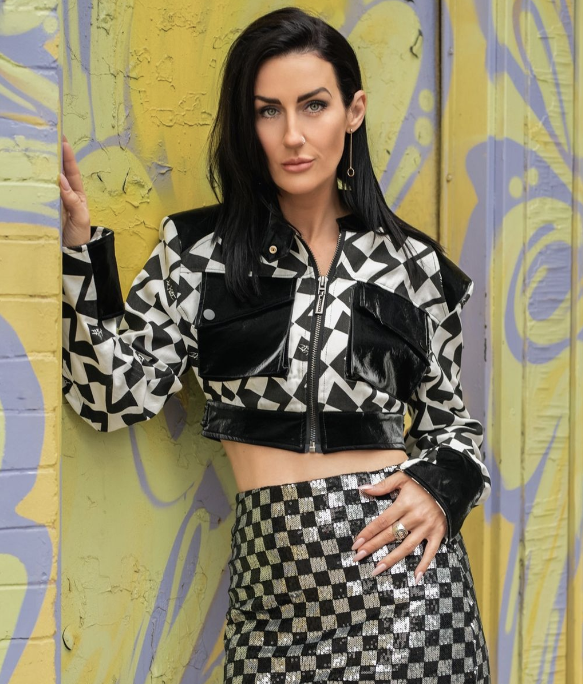 Kate, owner of Kate Hewko clothing, poses in an edgy metallic leather jacket and matching skirt.