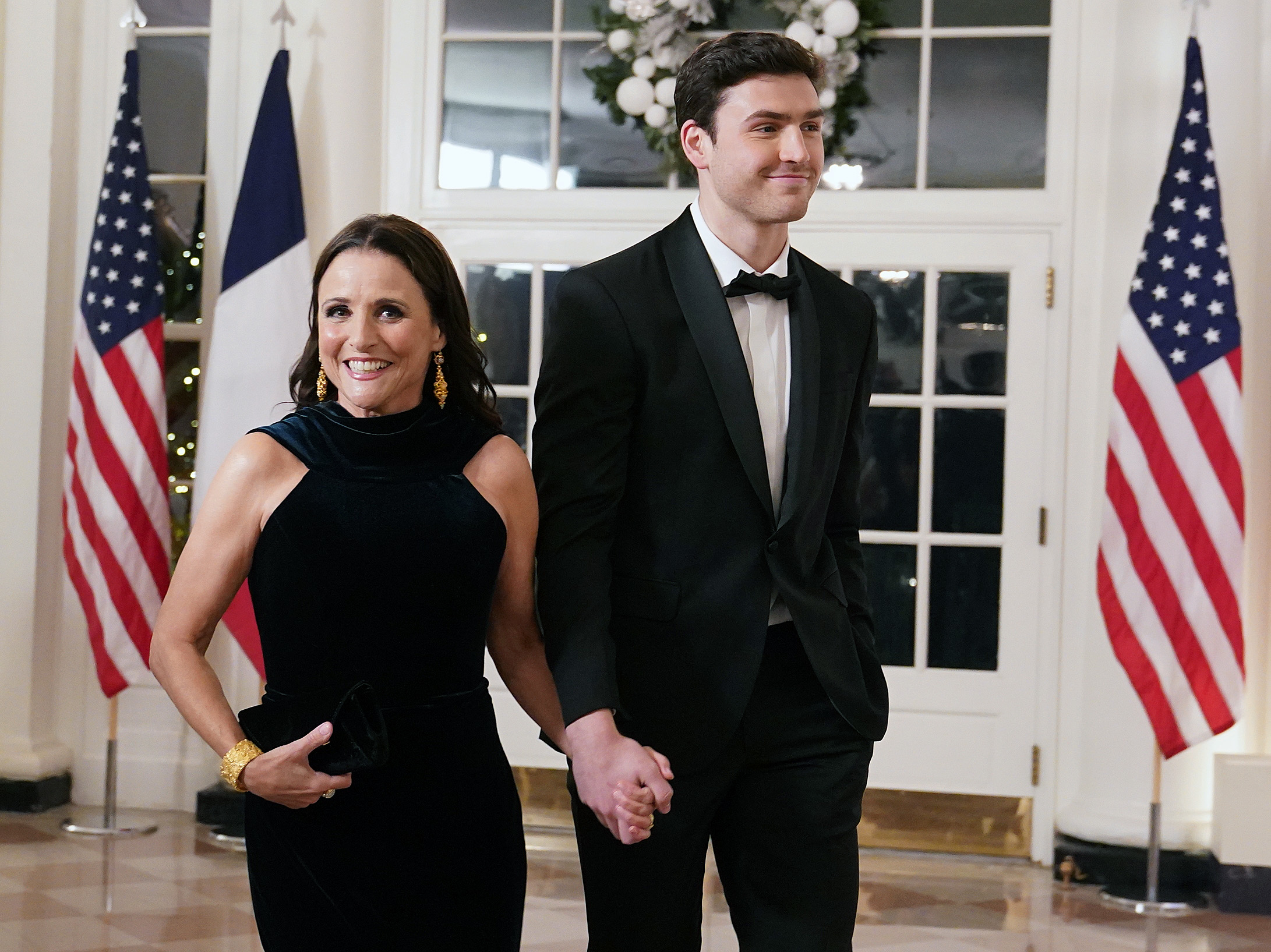 Charlie in a tux and Julia in a black dress as they walk into the White House