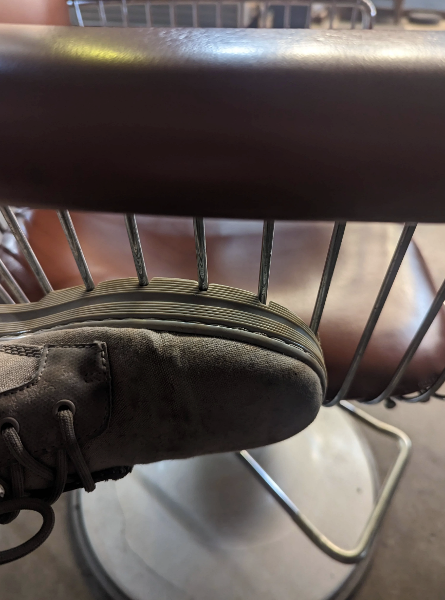 ridges on the bottom of the shoe perfectly match up with the metal bars on a chair