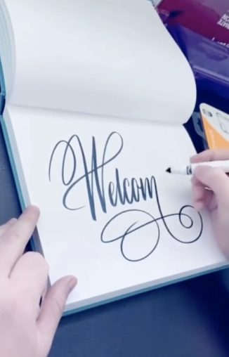 Someone writing cursive in a notebook
