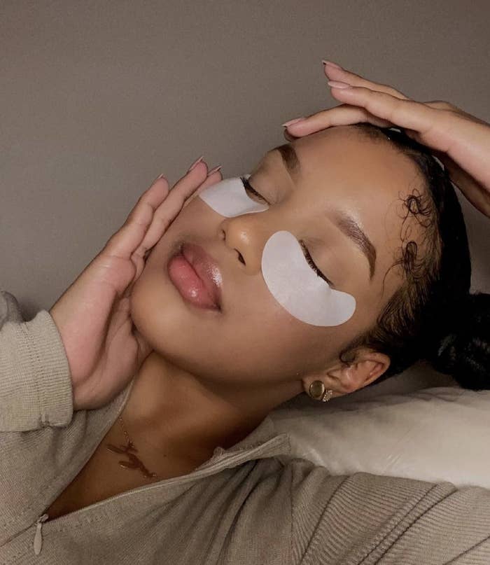 A woman poses with under-eye collagen masks.