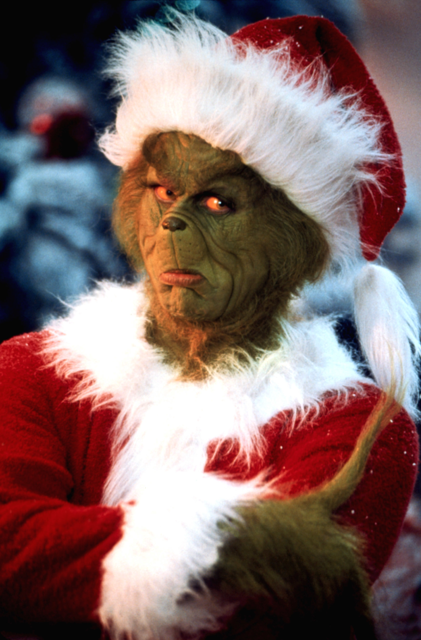 closeup of the grinch in a santa suit