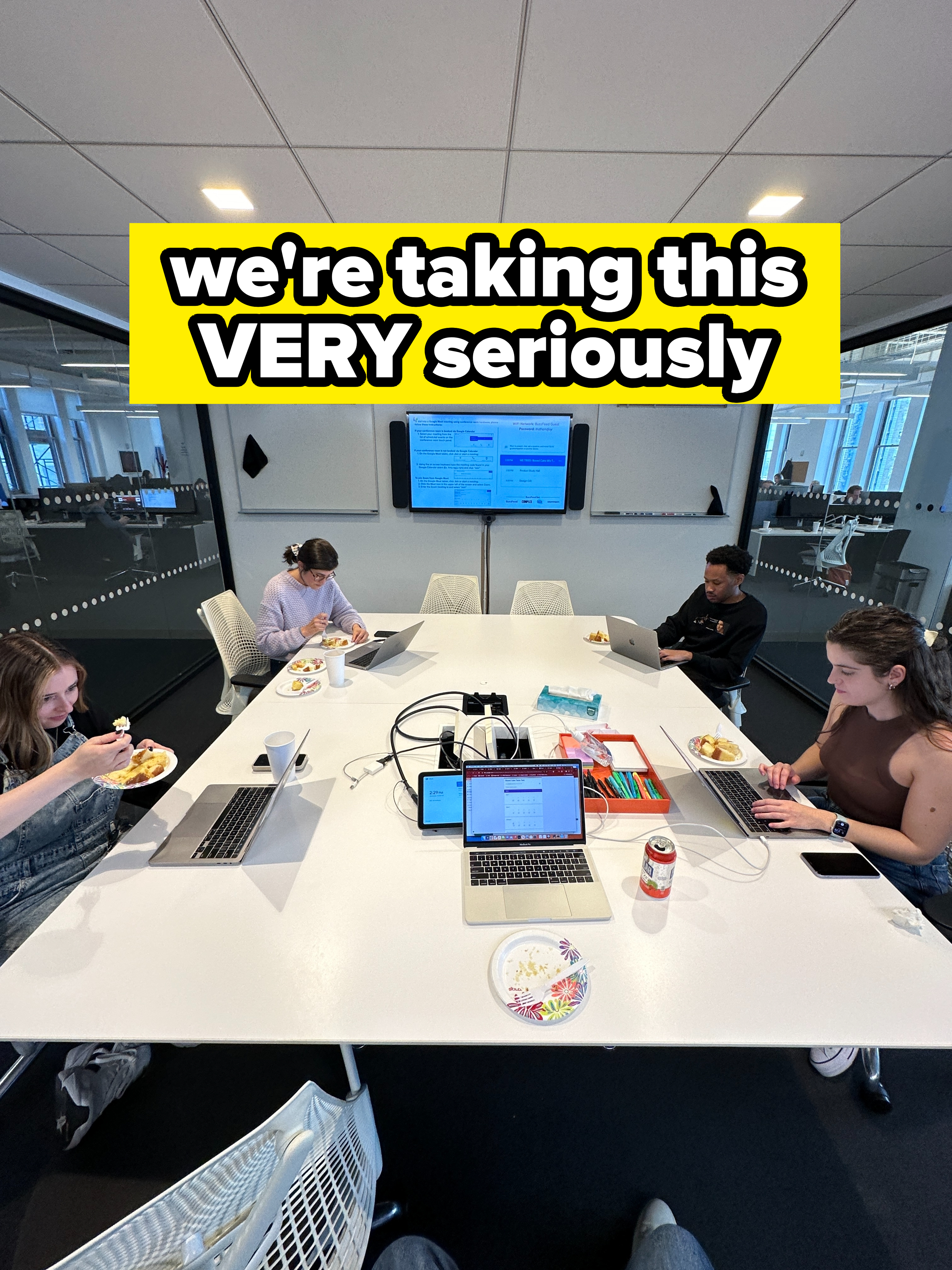 the author and her coworkers sitting in a conference room table with their laptops and plates of cake in front of them