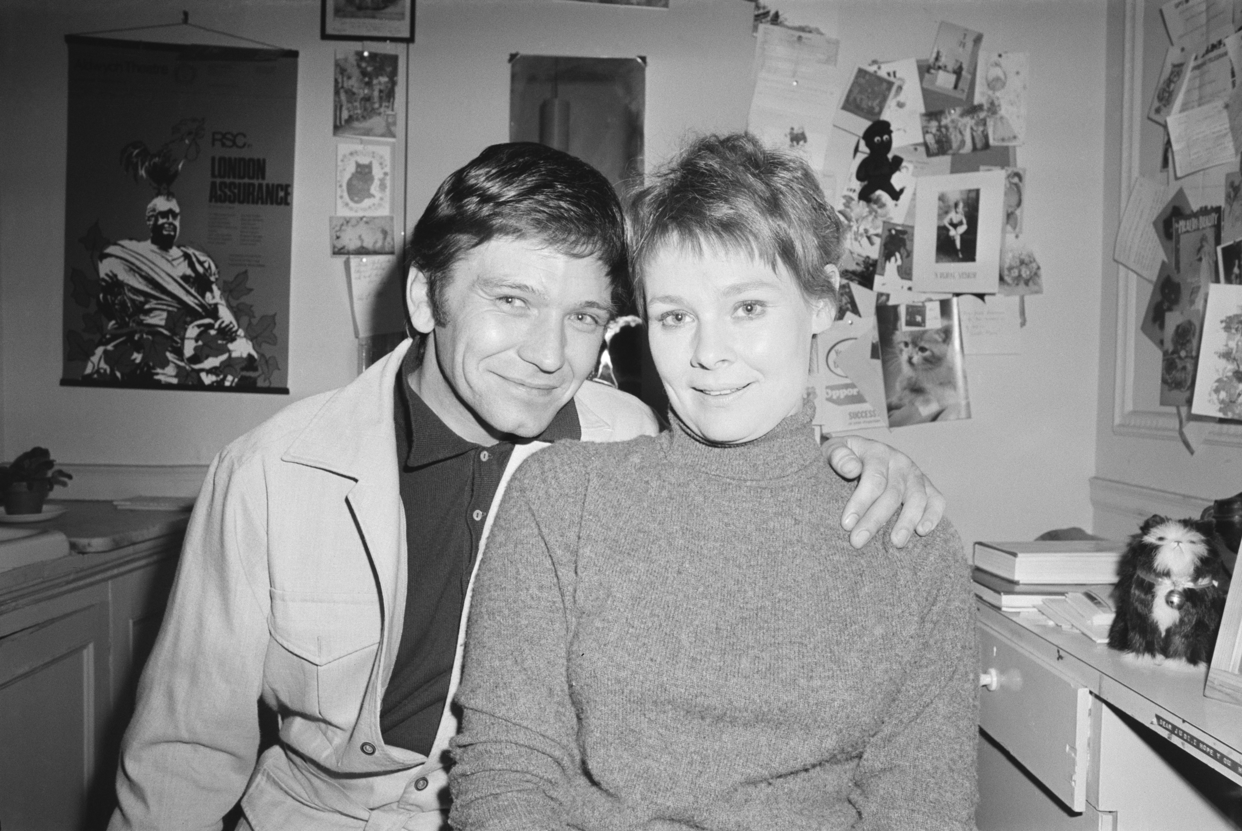 Judi in a high-neck sweater sitting with actor Michael Williams
