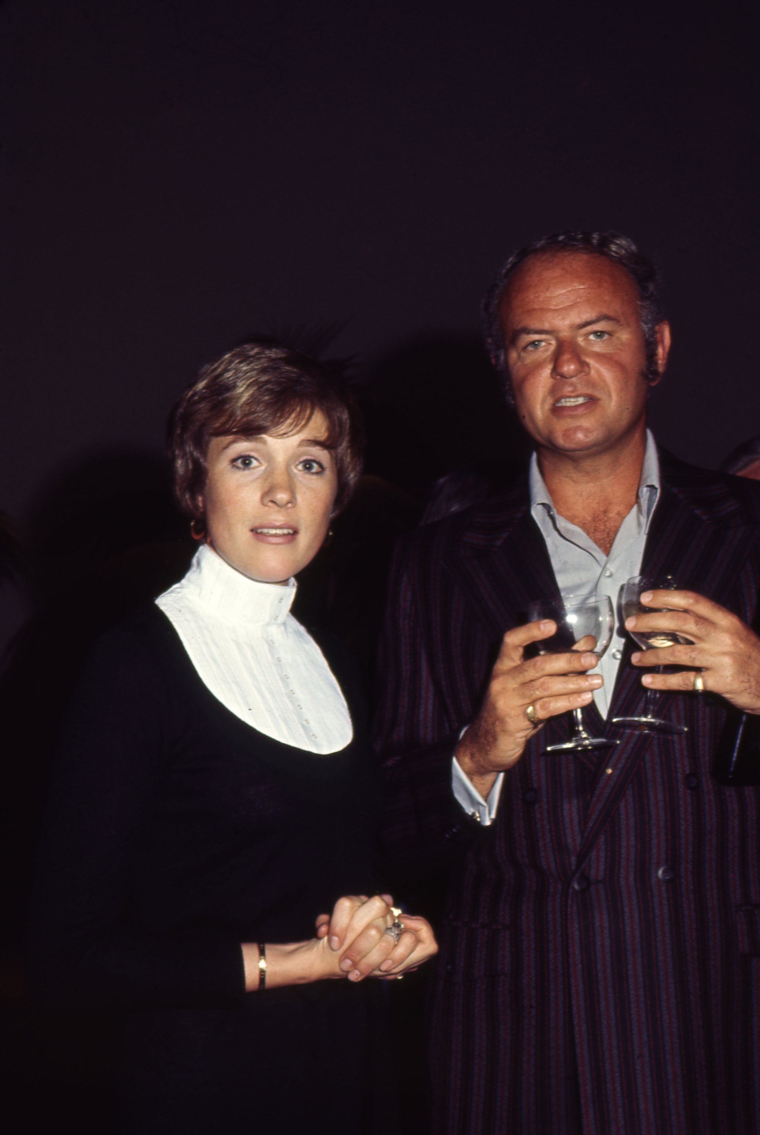 Julie in a high-neck outfit with a wide, white collar and standing with Harvey Korman