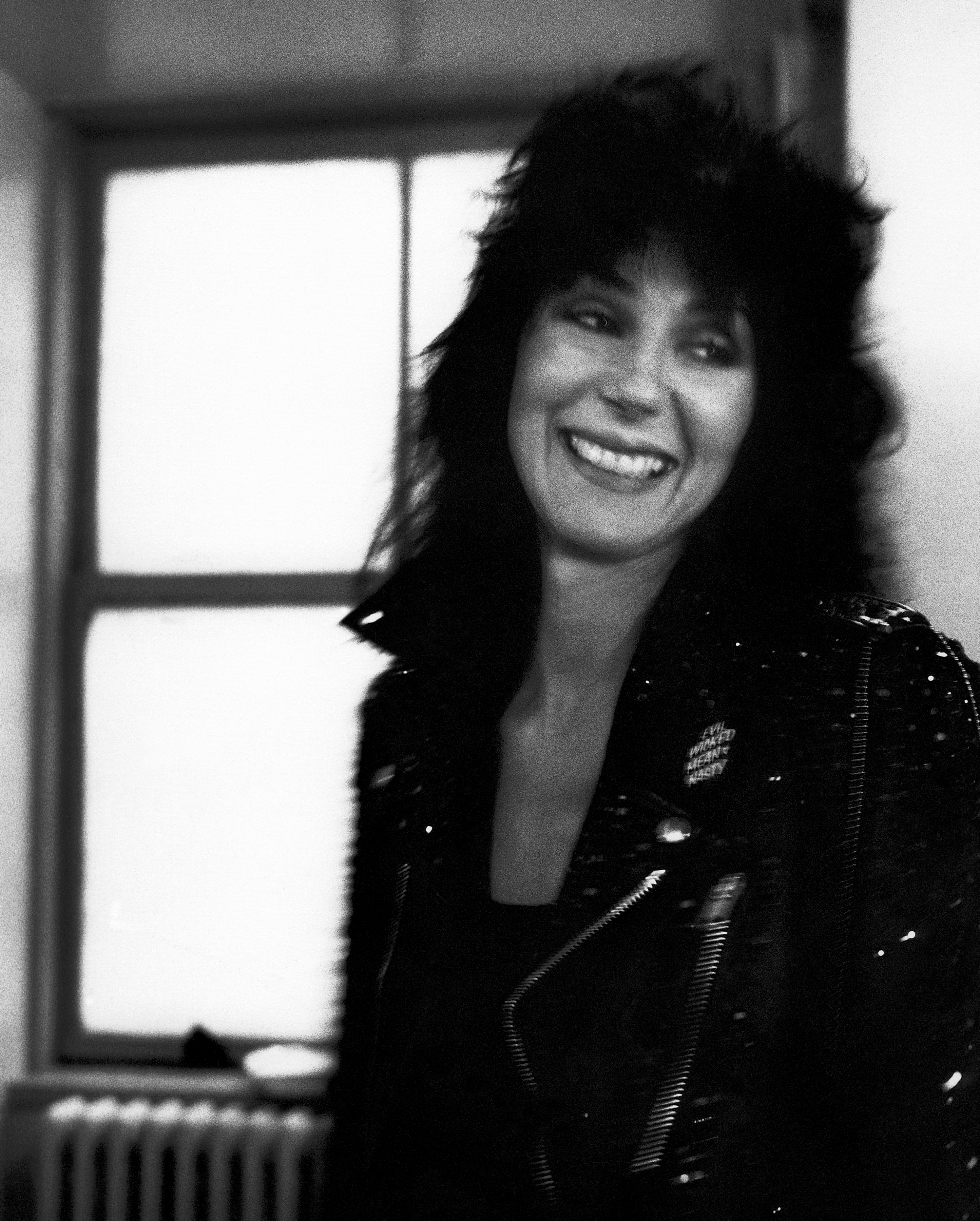Close-up of Cher smiling by a window