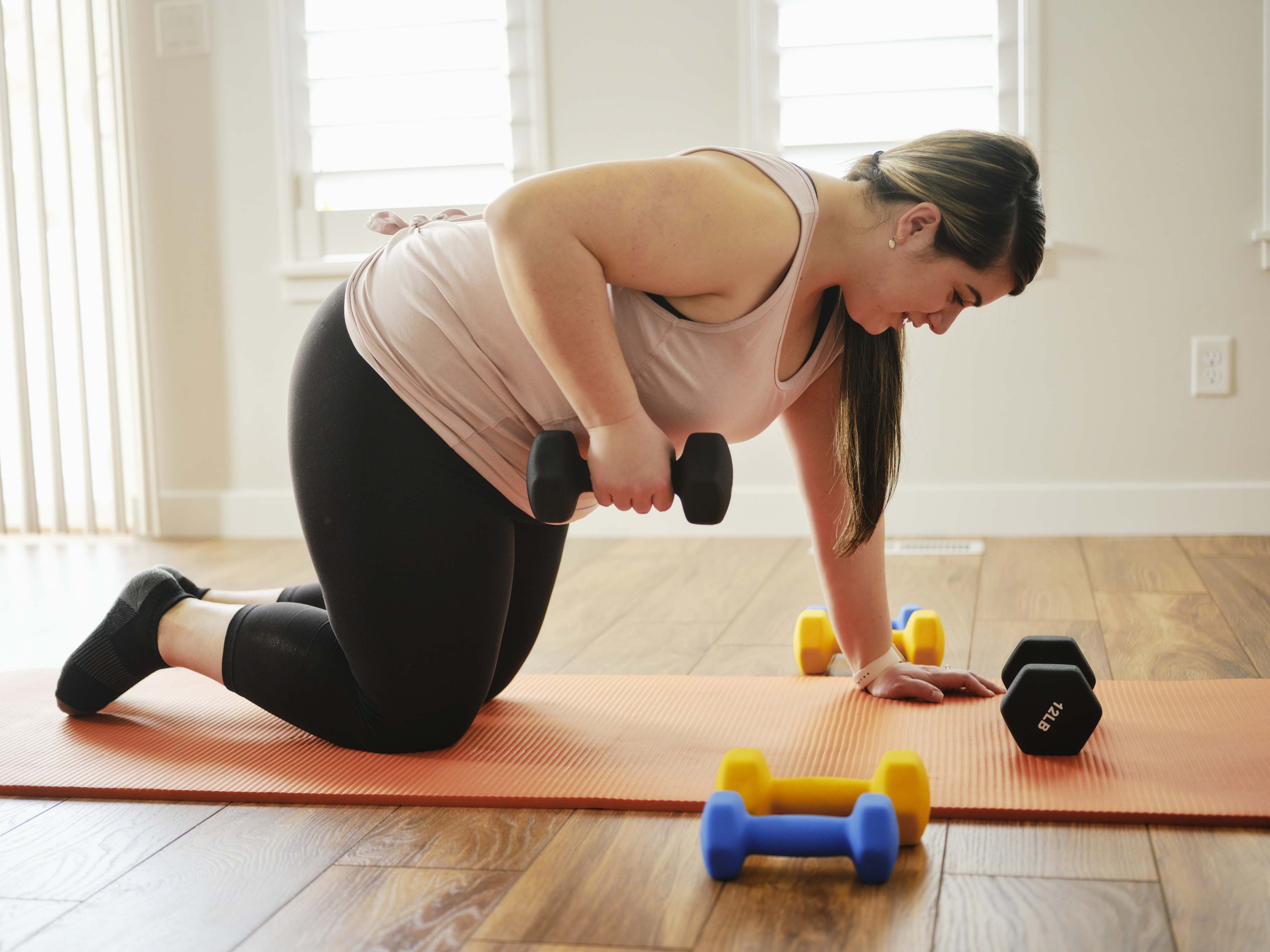 A woman exercising at home with hand weights