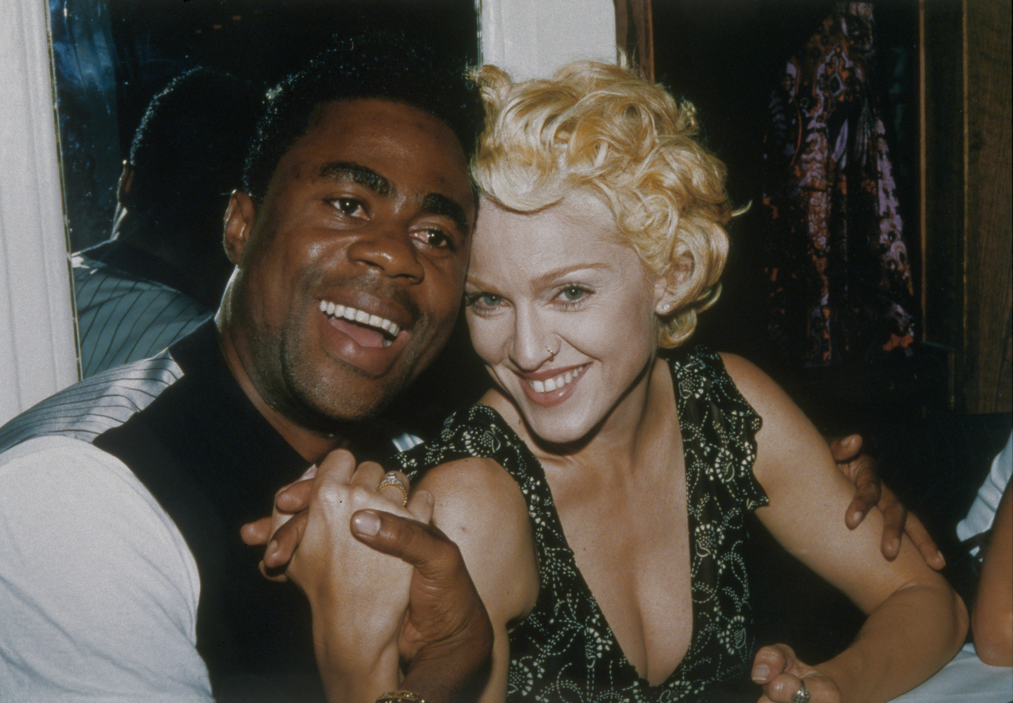 Madonna sitting and smiling while holding hands with a smiling man