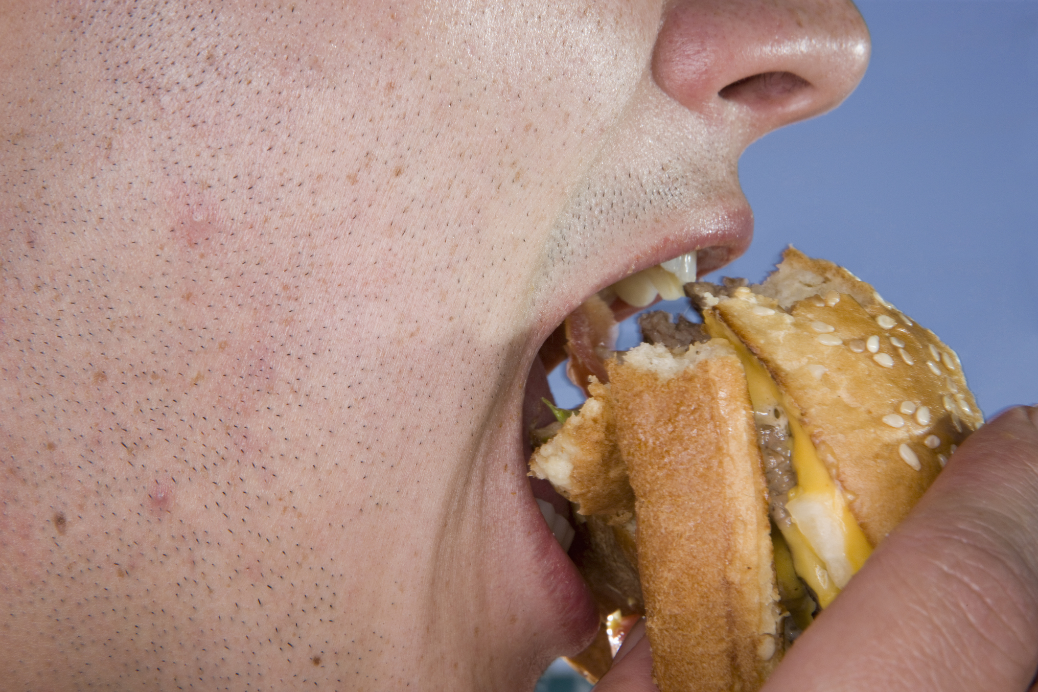 a person biting a burger