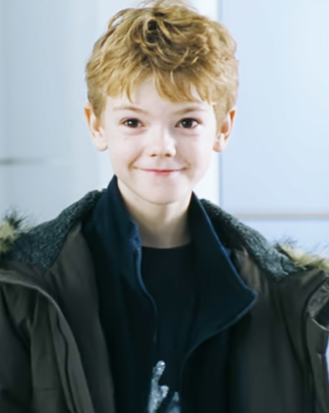 Close-up of Thomas smiling and wearing a jacket