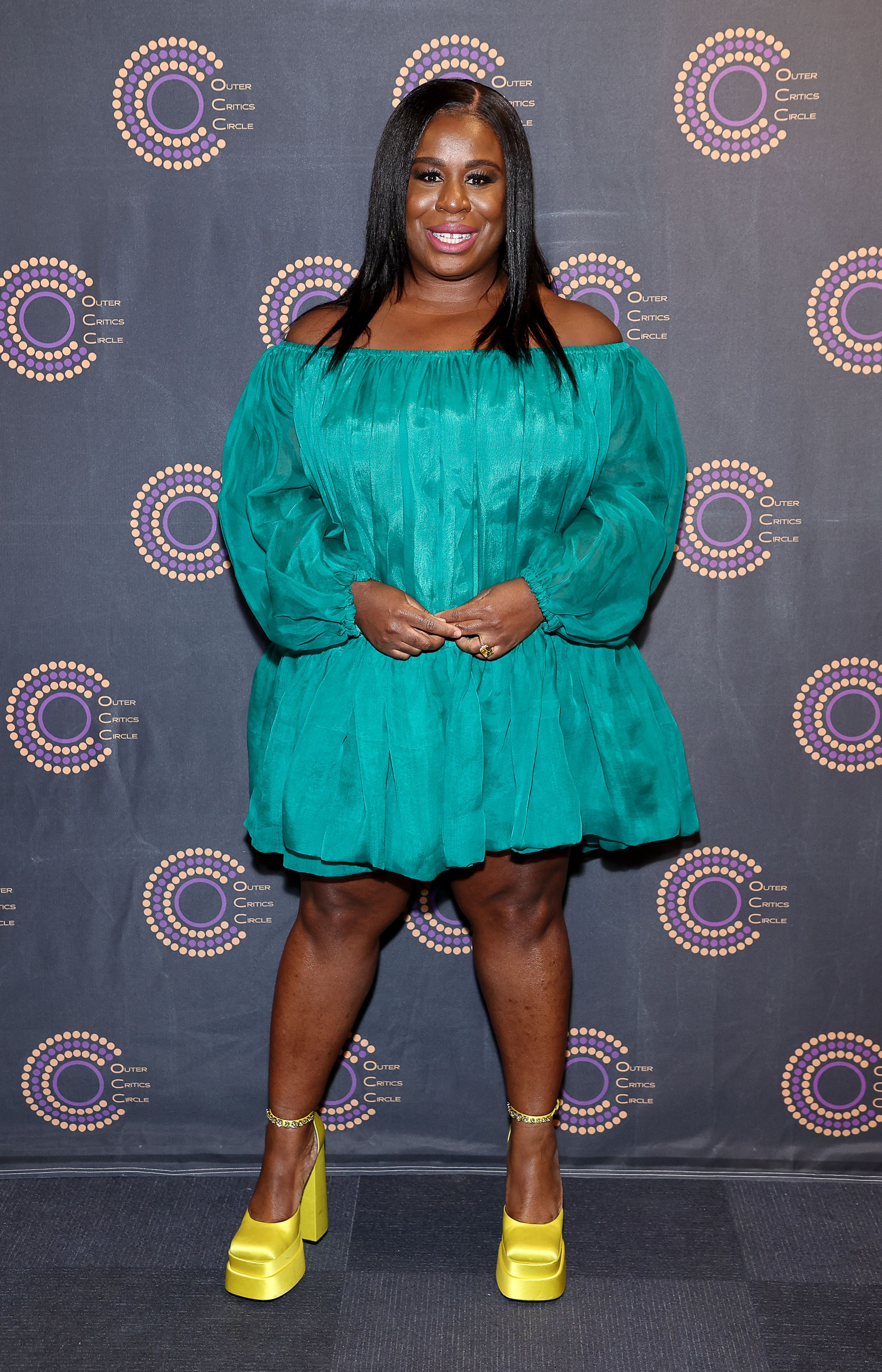 Uzo Aduba at a media event in a short dress and platform heels