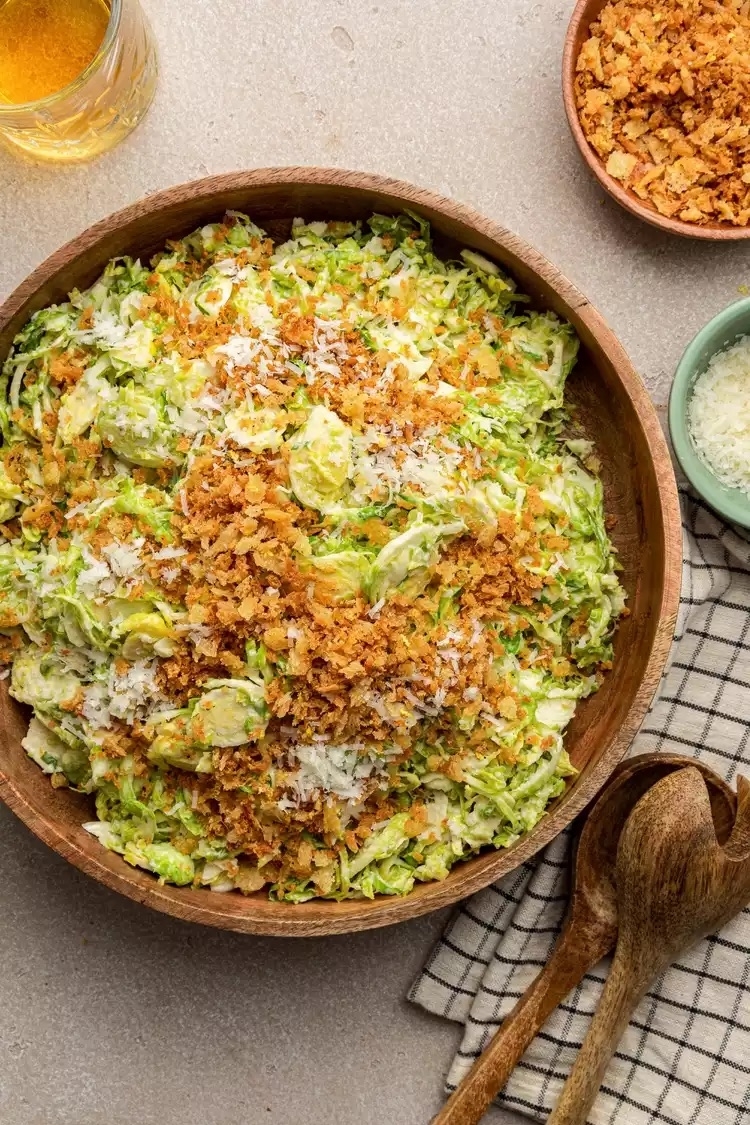 Shaved Brussels sprouts tossed in Caesar dressing topped with bread crumbs