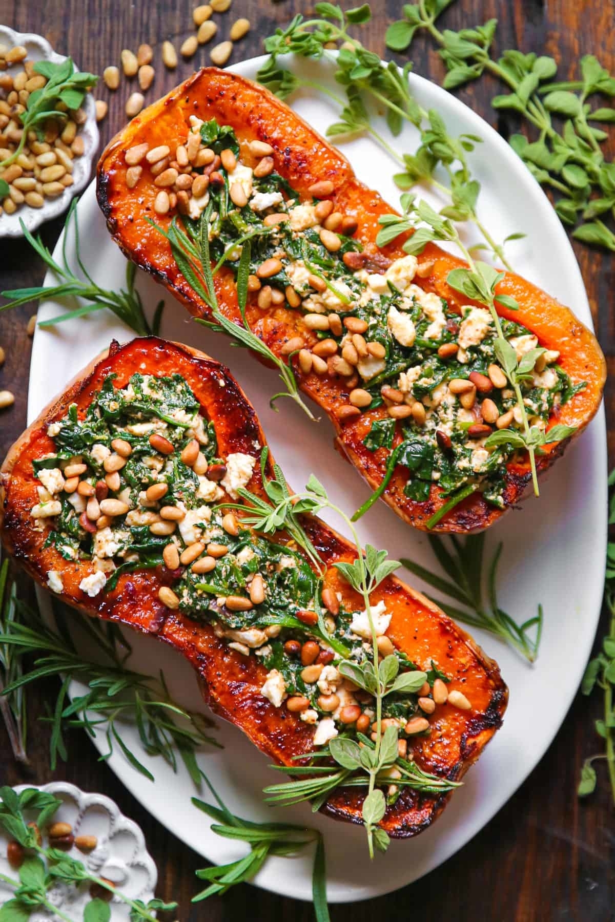 Two slices of roasted butternut squash stuffed with feta, spinach, and pine nuts